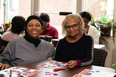 woman playing bingo with elderly woman