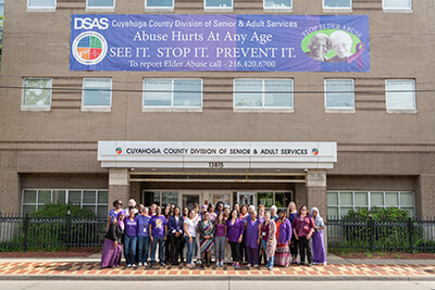 DSAS Workers standing in front of building with elder abuse banner