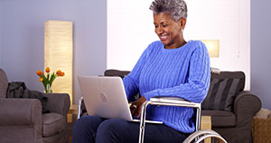 Elderly Woman in a wheelchair using a Laptop