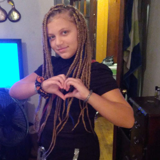 young woman smiling and making a heart with her hands