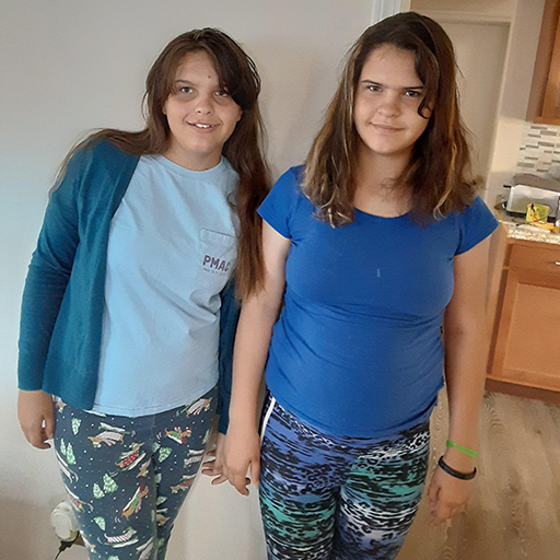 two sisters standing and smiling