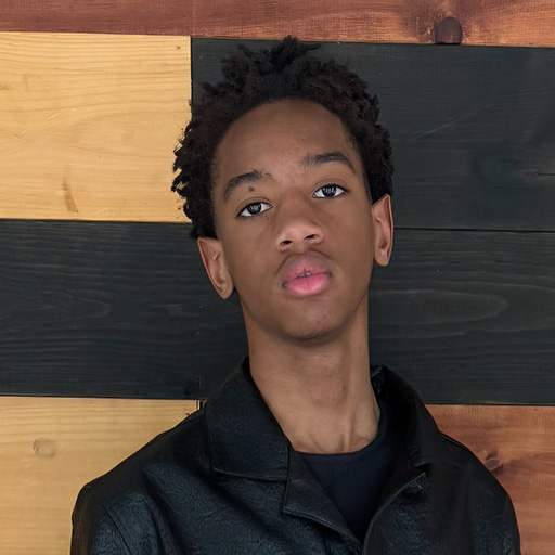 young man standing in front of a wooden wall