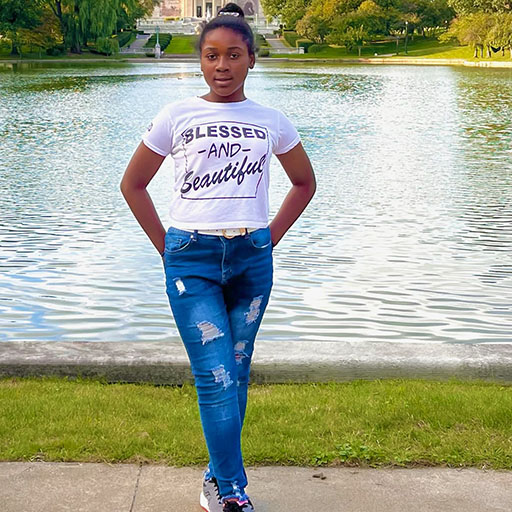 young woman standing near a pond and smiling