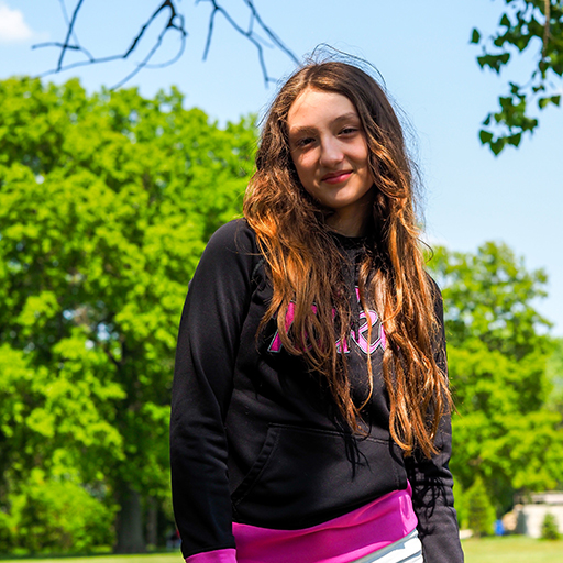 young woman standing outside and smiling