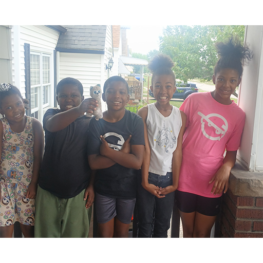 group of siblings standing outside and smiling