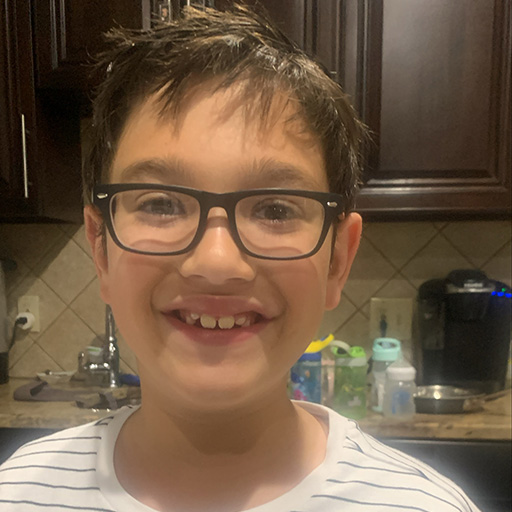 boy standing in a kitchen and smiling