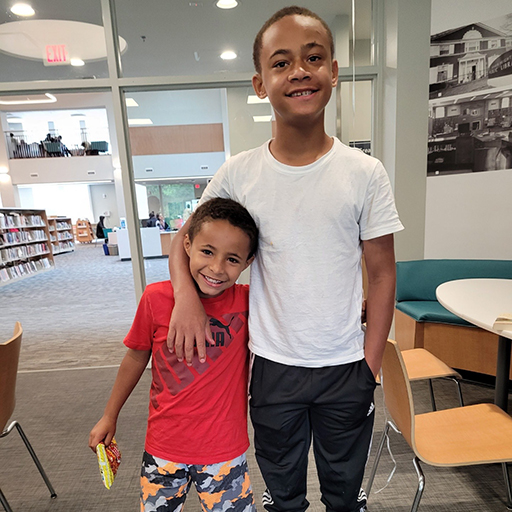 two brothers standing with arms around each other and smiling