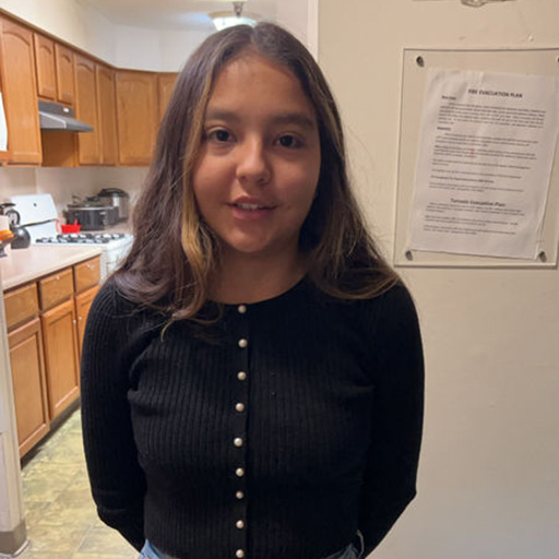 young woman standing near a kitchen and smiling