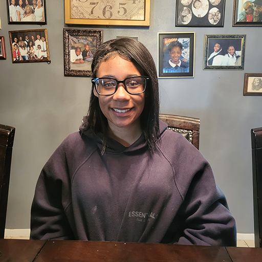 young woman sitting at a table and smiling