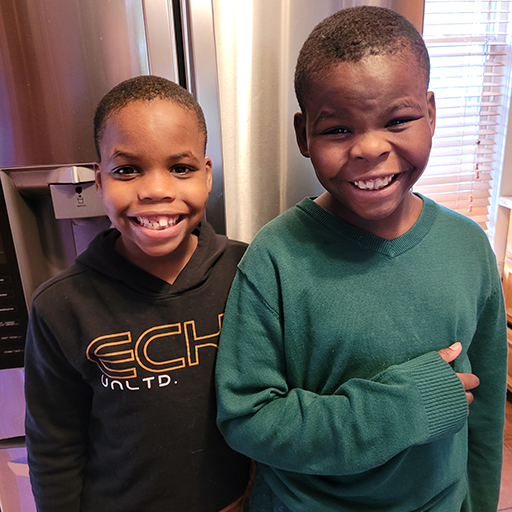 two children standing and smiling