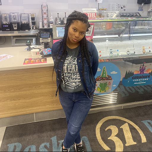 young woman standing in an ice cream shop and smiling