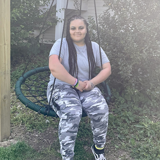 young woman sitting on a swing and smiling
